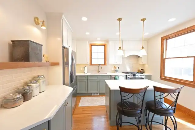 Lakewood, OH kitchen remodel with green lower cabinets, white quartz counters, floating wood shelf and gold pendants