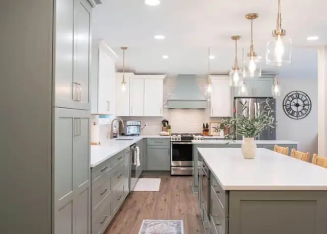 Solon, OH kitchen remodel with sage green cabinets, white quartz island, glass pendant lights and a stainless range
